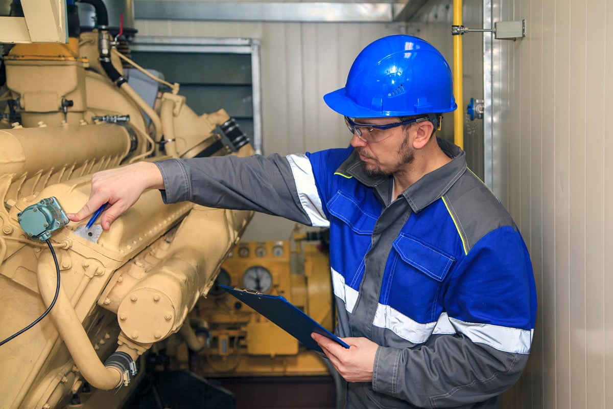 PowerChampions technician inspecting a diesel generator engine PowerChampions technician inspecting a diesel generator engine